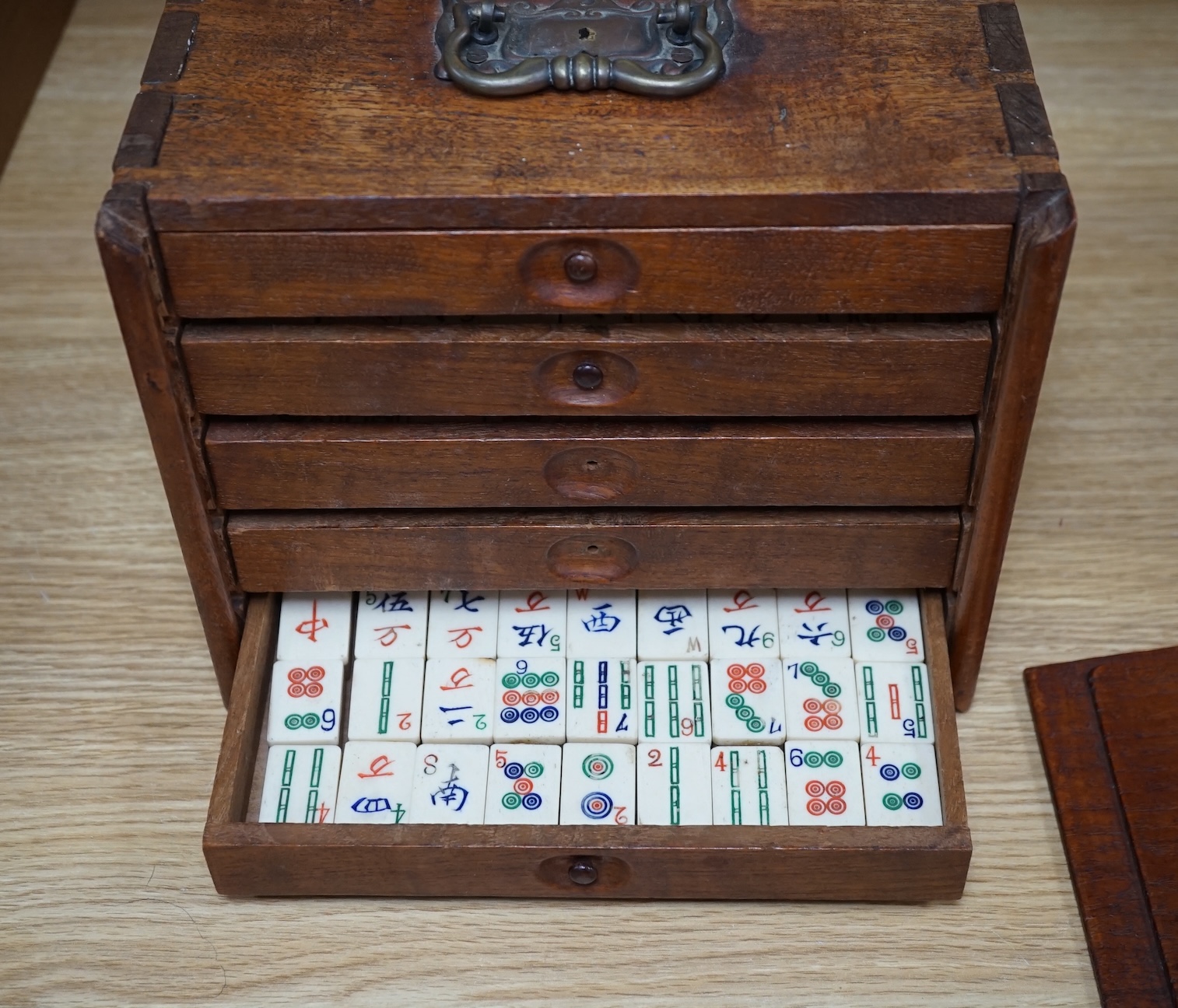 A Chinese boxed bone Mah jong set with five drawers, 19cm high. Condition - poor to fair, case damaged